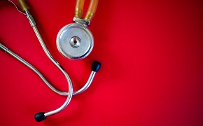 A stethoscope on a red background.